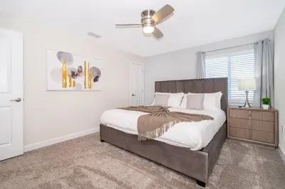 a bedroom with a bed and a ceiling fan at 4301WB TOWNHOUSE 5 BEDROOMS & 4 BATHROOMS + POOL in Kissimmee