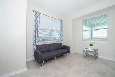 a living room with a couch and two windows at 3141-307DM STOREY LAKE, CONDO 2/2 LAKE VIEW in Kissimmee
