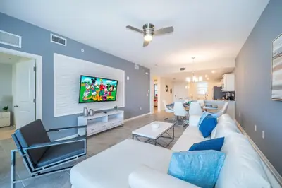a living room with a white couch and a tv at 3141-204LS STOREY LAKE, CONDO 2/2 LAKE VIEW in Kissimmee