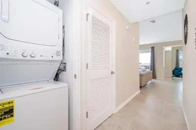 a kitchen with a washer and dryer next to a door at 3141-202RF STOREY LAKE, CONDO 2/2 LAKE VIEW in Kissimmee