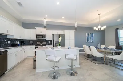 a kitchen with white cabinets and a table and chairs at 3141-405IL STOREY LAKE, CONDO 2/2 LAKE VIEW in Kissimmee