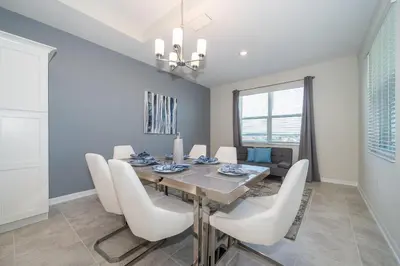a dining room with a table and white chairs at 3141-405IL STOREY LAKE, CONDO 2/2 LAKE VIEW in Kissimmee