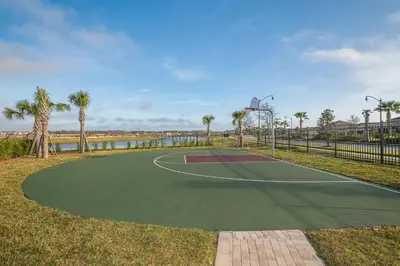 a tennis court with palm trees and a basketball hoop at 3141-405IL STOREY LAKE, CONDO 2/2 LAKE VIEW in Kissimmee