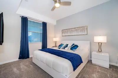 a white bedroom with a bed and a window at 3131-202JQ STOREY LAKE, CONDO 2/2 LAKE VIEW in Kissimmee