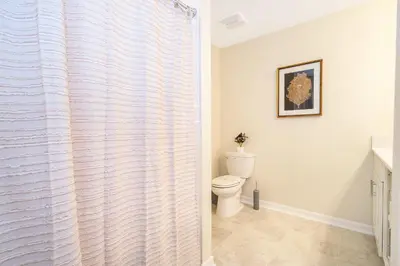 a bathroom with a toilet and a shower curtain at 3131-202JQ STOREY LAKE, CONDO 2/2 LAKE VIEW in Kissimmee