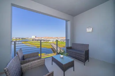 a balcony with chairs and a table and a large window at 3131-305RA STOREY LAKE, CONDO 2/2 LAKE VIEW in Kissimmee