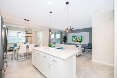a kitchen and dining room with white cabinets and a table at 3151-207NC STOREY LAKE, CONDO 2/2 LAKE VIEW in Kissimmee