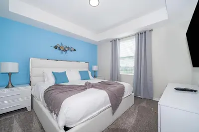 a bedroom with a white bed and blue walls at 3161-205RF STOREY LAKE, CONDO 2/2 LAKE VIEW in Kissimmee