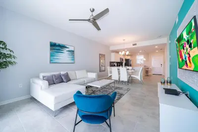 a living room with a white couch and a blue chair at 3161-205RF STOREY LAKE, CONDO 2/2 LAKE VIEW in Kissimmee