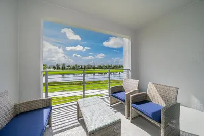 a balcony with two chairs and a window with a view at 3161-205RF STOREY LAKE, CONDO 2/2 LAKE VIEW in Kissimmee