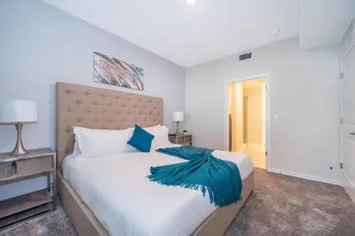 a bedroom with a large white bed with blue pillows at 3161-203FC STOREY LAKE, CONDO 2/2 LAKE VIEW in Kissimmee
