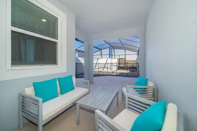 a balcony with two chairs and a table at 4381FA TOWNHOUSE 4 BEDROOMS & 3 BATHROOMS + POOL in Kissimmee