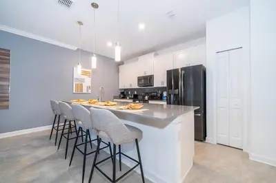 a kitchen with a large island with bar stools at 2984JP TOWNHOUSE 4 BEDROOMS & 3 BATHROOMS + POOL in Kissimmee