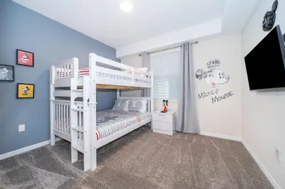 a white bunk bed in a room with a tv at 3171-204AZ STOREY LAKE, CONDO 2/2 LAKE VIEW in Kissimmee