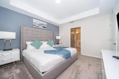 a bedroom with a large bed with blue walls at 3171-204AZ STOREY LAKE, CONDO 2/2 LAKE VIEW in Kissimmee