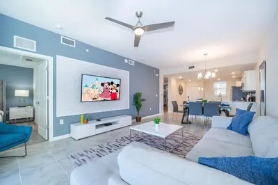 a living room with a white couch and a blue wall at 3171-204AZ STOREY LAKE, CONDO 2/2 LAKE VIEW in Kissimmee
