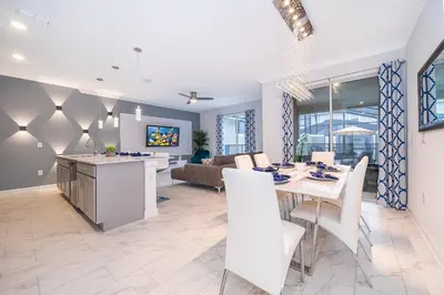 a kitchen and living room with a table and chairs at 4202MC TOWNHOUSE 4 BEDROOMS & 3 BATHROOMS + POOL in Kissimmee