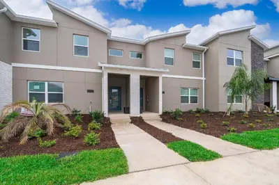 a large apartment building with a driveway at 4202MC TOWNHOUSE 4 BEDROOMS & 3 BATHROOMS + POOL in Kissimmee