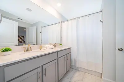 a bathroom with two sinks and a shower at 4202MC TOWNHOUSE 4 BEDROOMS & 3 BATHROOMS + POOL in Kissimmee