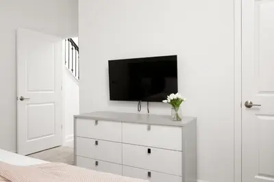 a white bedroom with a dresser with a tv on it at Last Minute Disney Getaway Private Pool Themed Bedrooms. Book Now 56757 in Kissimmee