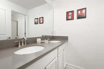 a bathroom with two sinks and a large mirror at Last Minute Disney Getaway Private Pool Themed Bedrooms. Book Now 56757 in Kissimmee