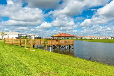 a wooden dock with a gazebo on the water at Last Minute Disney Getaway Townhouse with Private Pool. Book Now 17066 in Kissimmee