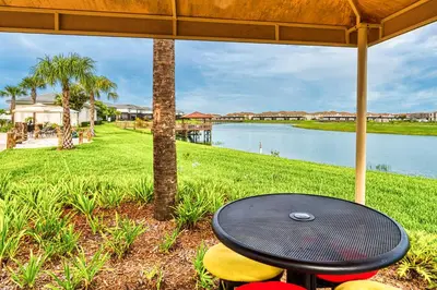 a table and chairs with a view of a lake at Last Minute Disney Getaway Townhouse with Private Pool. Book Now 21174 in Kissimmee