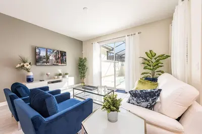 a living room with blue and white furniture and a window at Last Minute Disney Getaway Townhouse with Private Pool. Book Now 21174 in Kissimmee