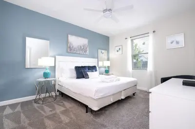 a bedroom with a white bed and a blue wall at Last Minute Disney Private Pool Hot Tub Game Room Themed Bedrooms. Book Now 29466 in Kissimmee