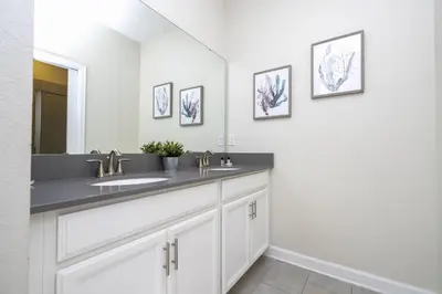 a bathroom with a sink and a mirror at Last Minute Disney Private Pool Hot Tub Game Room Themed Bedrooms. Book Now 29466 in Kissimmee
