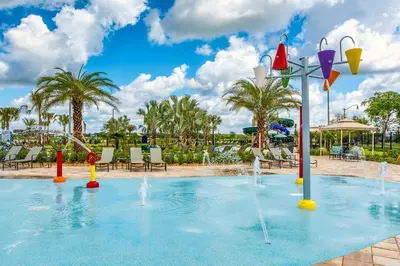 a pool with water fountains in a resort at Last Minute Disney Getaway! Private Pool, Hot Tub & Games Room. Book Now! #17050 in Kissimmee