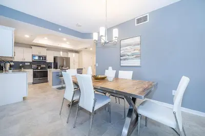 a kitchen and dining room with a wooden table and white chairs at 4721-201AB STOREY LAKE, CONDO 3/2 GARDEN VIEW in Kissimmee