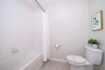 a white bathroom with a toilet and a bath tub at 4721-201AB STOREY LAKE, CONDO 3/2 GARDEN VIEW in Kissimmee