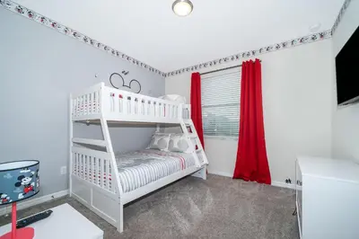 a bedroom with a white bunk bed and a red curtain at 4721-201AB STOREY LAKE, CONDO 3/2 GARDEN VIEW in Kissimmee