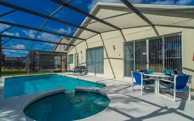 a swimming pool with a table and blue chairs at 2025 Vacation Savings Secure Your Spot Today in Orlando