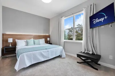 a bedroom with a bed and a window and a chair at Luxury Villa 5BedroomsPool- 4 miles from Disney in Orlando