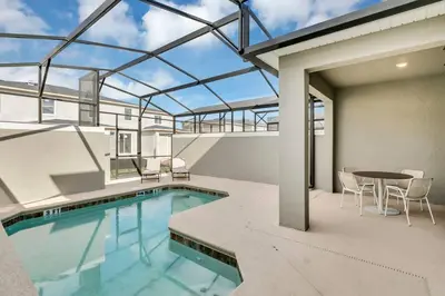 an indoor pool with a table and chairs on a patio at Stylish Family Home - Private Pool - STL111 in Kissimmee