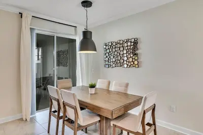 a dining room with a wooden table and chairs at Stylish Family Home - Private Pool - STL111 in Kissimmee