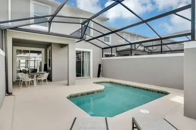 a swimming pool on a patio with a house at Stylish Family Home - Private Pool - STL111 in Kissimmee