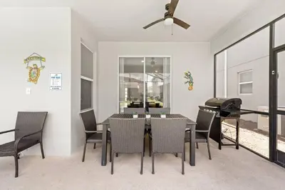 a dining room with a table and chairs and a piano at Relax & Unwind Chic Pool Home Near Disney Fun! - STL113 in Kissimmee