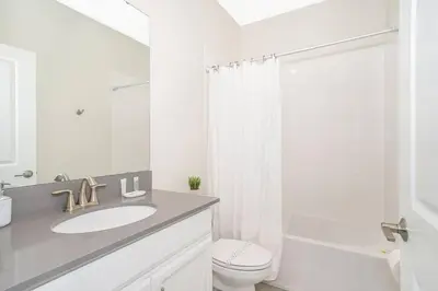 a white bathroom with a sink and a toilet at Relax & Unwind Chic Pool Home Near Disney Fun! - STL113 in Kissimmee