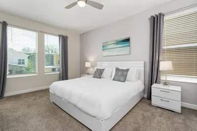 a white bedroom with a white bed and windows at Relax & Unwind Chic Pool Home Near Disney Fun! - STL113 in Kissimmee