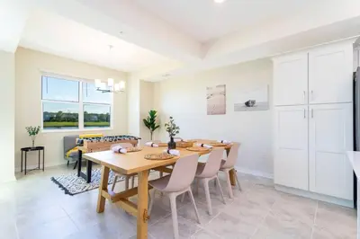 a kitchen and dining room with a wooden table and chairs at Lovely Condo Access to Amazing Resort STL115 in Kissimmee
