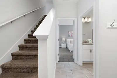 a white hallway with stairs and a bedroom at Really close to Disney! Sleeps 10 - STL116 in Kissimmee
