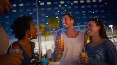 a group of people standing around with drinks at Universal's Stella Nova Resort in Orlando