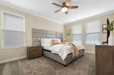 a bedroom with a bed and a ceiling fan at Home away from Home! 6BR, 5.5 BA - STL118 in Kissimmee