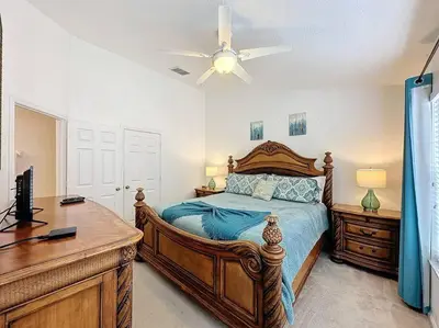 a bedroom with a bed and a desk and a ceiling fan at Sunnyside Up Gated Resort Style Community in Orlando