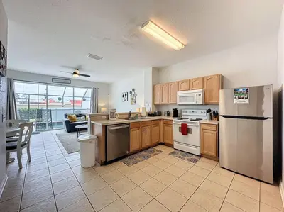 a kitchen with stainless steel appliances and a living room at Sunnyside Up Gated Resort Style Community in Orlando