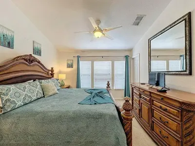a bedroom with a bed and a dresser with a mirror at Sunnyside Up Gated Resort Style Community in Orlando