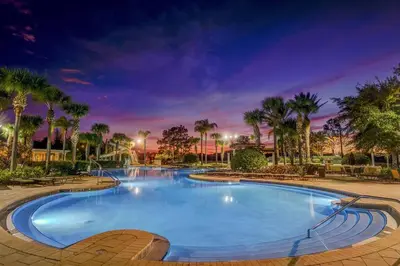 a large swimming pool with palm trees in a resort at Sunnyside Up Gated Resort Style Community in Orlando